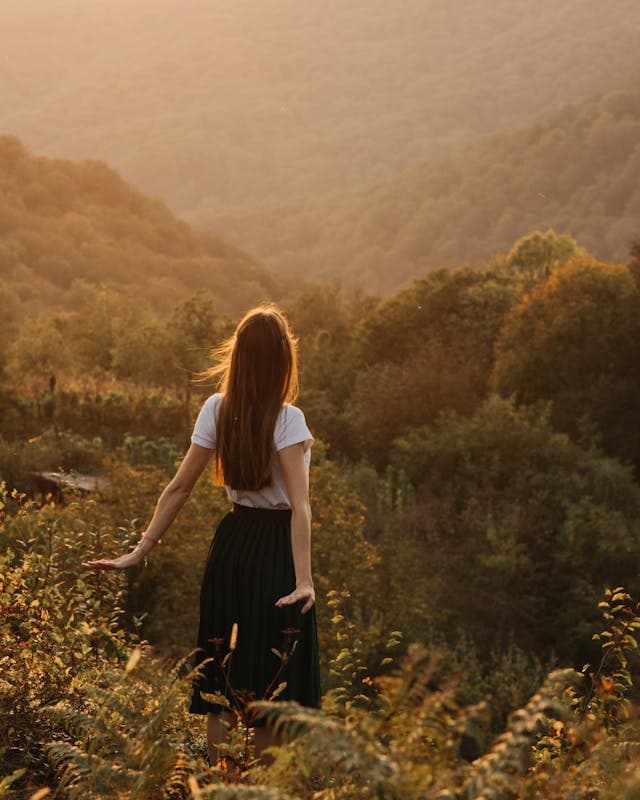 Woman with hands out in lush medow