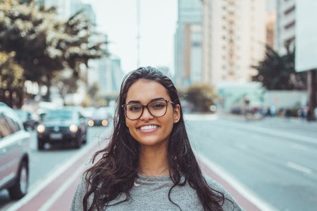 Woman in glasses smiling into camera